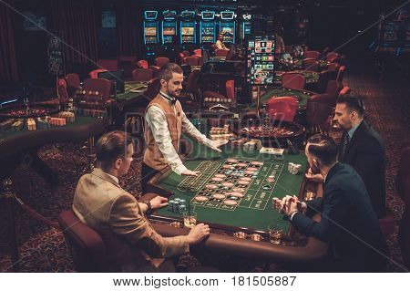 Upper class friends gambling in a casino.