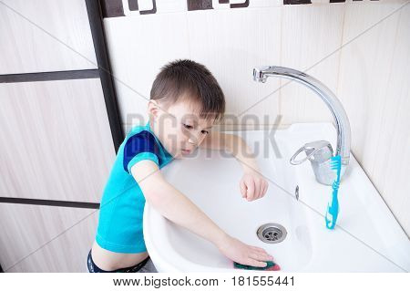 Boy cleaning in bathroom wash sink child doing up housework helping mother with sanitary cleanness of home traiding kid for housekeeping