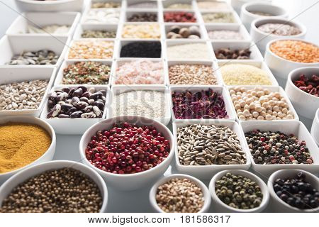 Spices and leguminous vegetables in bowls, isolated on white background