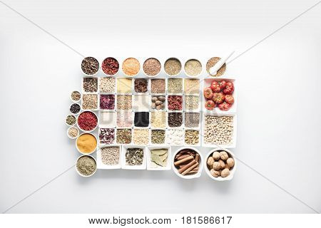 Spices and leguminous vegetables in bowls, isolated on white background