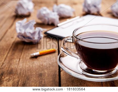 Crumpled paper balls with pencil and clipboard on wooden background and