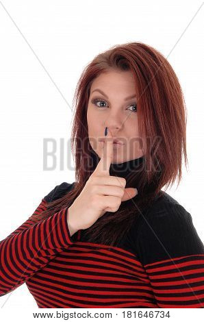 A pretty woman in a red and black striped dress holding her finger over her mouth isolated for white background.