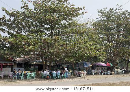 SITTWE, MYANMAR - FEBRUARY 2, 2007:People sitting in an outdoor terrace while waiting for the next flight at the Sittwe airport Myanmar