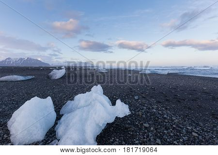 Ice on black sand beach with mountain background Iceland winter season landscape background