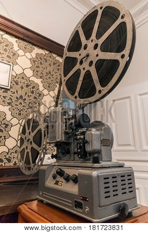 Retro style vintage metal movie projector with film reel, movie equipment of last century