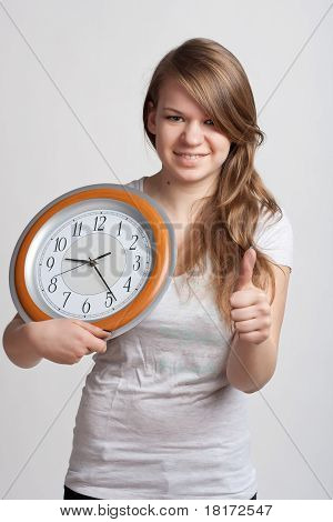 Bella ragazza con un grande orologio nelle sue mani