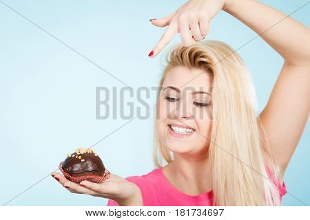 Woman Holding Chocolate Cupcake About To Bite