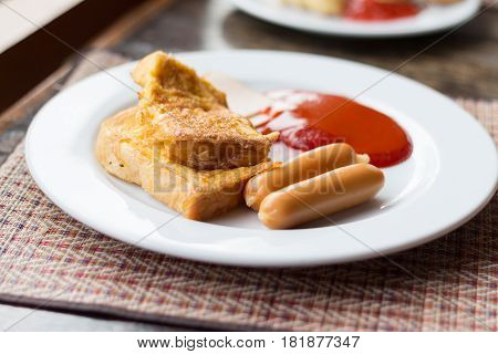 A typical American hearty breakfast with sausage ham Omelette and catchup