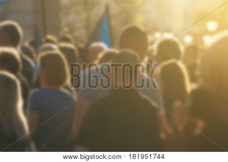 Large group of unrecognizable people as audience to politician's speech outdoors defocused crowd attending political meeting
