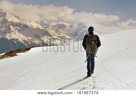 hiker with backback walking in the snow