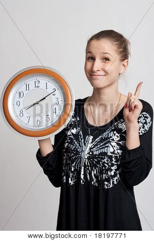 Bella ragazza con un grande orologio nelle sue mani