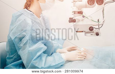 Lasik Treatment. Laser Vision Correction. Doctor Examines Fundus In Microscope, Patient Under Steril