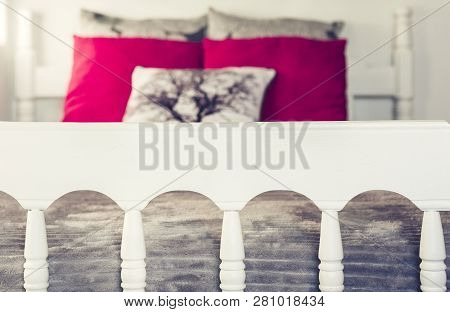 White Wooden Carved Bed With Gray Bedspread And Red Pillows