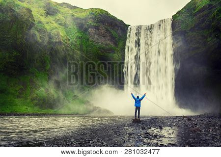 Single Man Standing Near Scogafoss Waterfall In Iceland And Spread His Hands. Travel Summer Nordic C