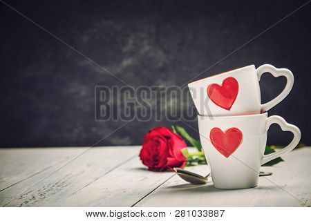 Valentine's Day concept. Red Cups and roses on a Wooden Background.