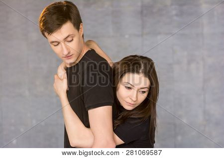 Young Pretty Dancer Hugging Her Partner. Couple Of Modern Style Dancers Posing On Studio Background.