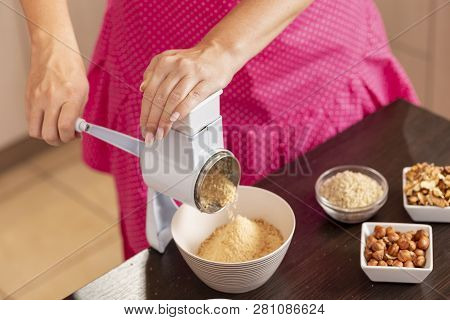 High Angle View Of A Woman Grinding Biscuits In A Biscuit Grinding Machine. Selective Focus On The H