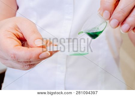 A Young Woman Doctor Distributes Portions Of Drugs In The Hospital, Determining Each Put Milliliters