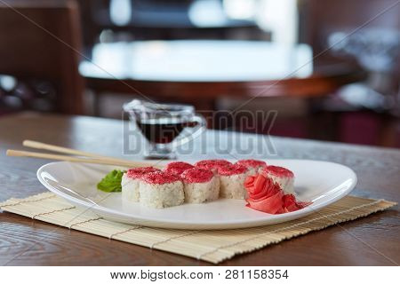 Rolls With Rice, Red Caviar, Sesame, At A Plate With Wasabi, Pickled Ginge, Chopsticks, Onto Bamboo 