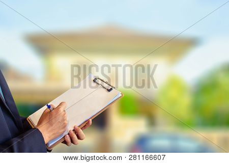 Man Business Salesman Sell House With Computer On House And Tree Blurry Background.for Home Business
