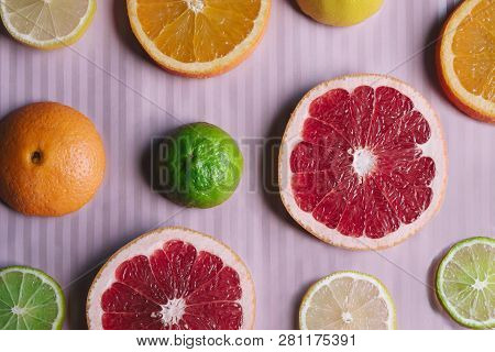 Striped Pink  Background With Citrus Slices: Orange, Grapefruit, Lemon, Lime. Contrast Of Colors. Ra