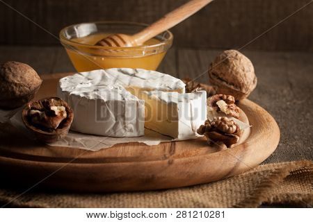 Camembert And Brie Cheese On Wooden Background With Tomatoes, Letuce And Garlic. Italian Food. Dairy