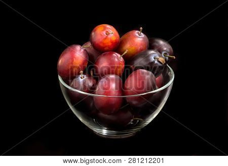 Fresh Plum In A Transparent Plate On A Black Background
