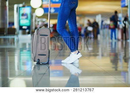 Closeup Of Woman Legs With Luggage In International Airport. Tourism And Travel Concept