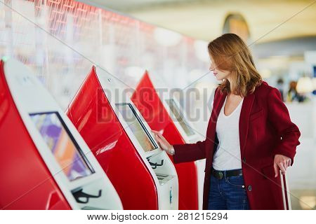 Young Woman In International Airport Doing Self Check-in