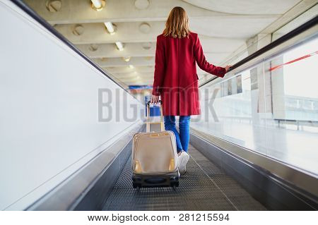 Young Woman In International Airport With Luggage On Travelator