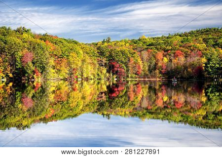 The Colorful Trees Of Autumn Reflecting Off Of The Waters In Burr State Park In Torrington, Connecti