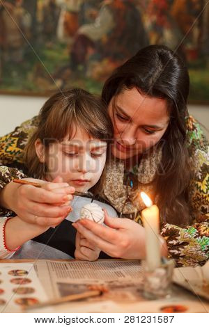 Lviv, Ukraine - March 11, 2018. Mom And Daughter Paint Easter Eggs At The Table