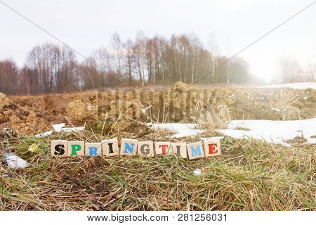 A Colorful Inscription Spring Made Up Of Wooden Cubes Stands On A Plowed Field In Spring. The Beginn