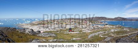 Rodebay, Greenland - July 09, 2018: Colorful Wooden Houses With Icebergs In The Background. Rodebay,
