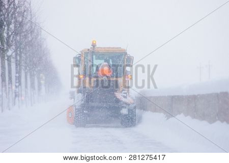 Snowplow Truck Vehicle Removing Snow During Heavy Blizzard Or Snowstorm. Urgent City Street Cleaning