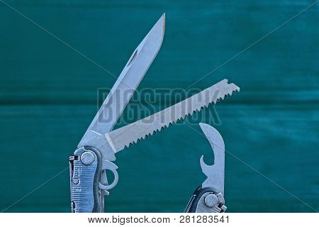 Part Of Gray Metal Multitool On A Green Background