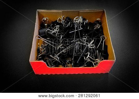 Box of binder clips binderclips office supplies of paperclips on desk