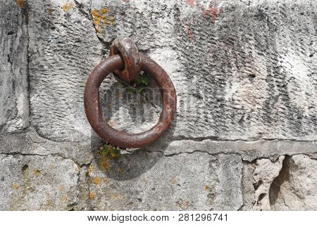 Rusty metal mooring ring on the quayside of the Oleron Island harbour, in France.