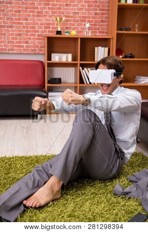 Young employee with virtual glasses during break in the office 