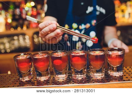 Bartender Man Making Hot Alcohol Shots On The Bar In The Pub With A Professional Burner. The Bartend