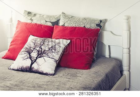 White Wooden Carved Bed With Gray Bedspread And Red Pillows