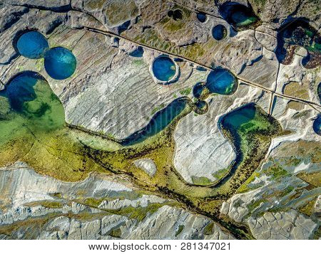 Deep Blue Colours Of The Deep Rock Pools And Lighter Aqua Yellows Of The Shallower Pools As Seen Fro