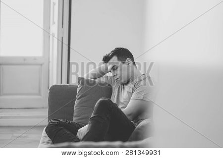 Young Attractive Man Suffering From Depression In Emotional Pain Lying On Couch At Home