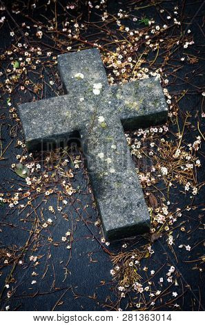 Closeup on a stone cross on a tomb in a cemetery