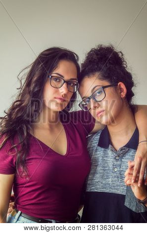 Studio portrait of two sisters wearing glasses