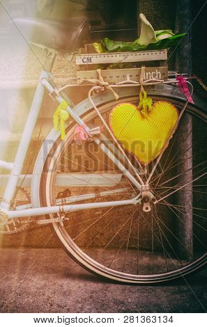 Detail of a vintage bicycle with a heart-shape pillow and basket