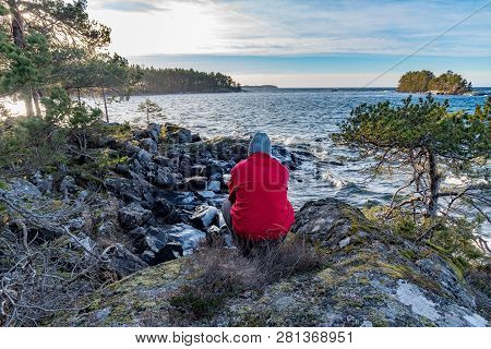 Man In Red Jacket Overlooking A Lake