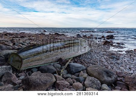 Rowing Boat Upsidedown On A Rocky Beach
