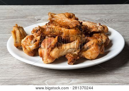 Fried Chiken Wings In The White Plate On Wooden Background
