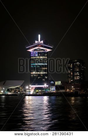 Amsterdam, Netherlands - November 22, 2018: City Night View Of Dam Toren Seen From The Water In Amst